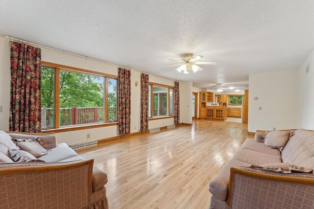 N3045 Lakeview Dr, Montello, WI 53949 - living area with a ceiling fan, light wood-style flooring, a textured ceiling, and a baseboard radiator