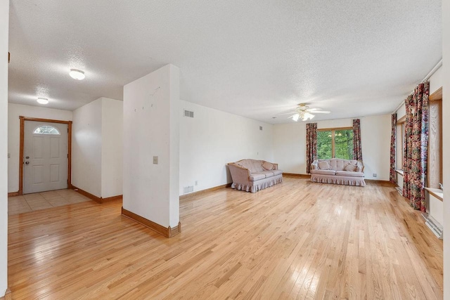 N3045 Lakeview Dr, Montello, WI 53949 - unfurnished living room with a textured ceiling, light wood-style flooring, and a ceiling fan