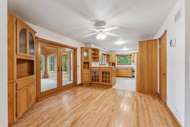 N3045 Lakeview Dr, Montello, WI 53949 - unfurnished living room featuring light wood-style flooring, french doors, a textured ceiling, and a ceiling fan