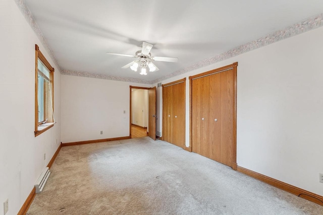 N3045 Lakeview Dr, Montello, WI 53949 - unfurnished bedroom with two closets, light colored carpet, a baseboard heating unit, and ceiling fan