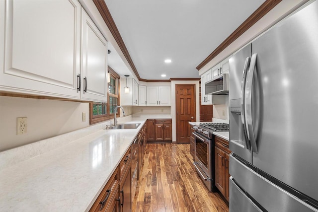 535 Maple Bluff Rd, Stevens Point, WI 54482 - kitchen featuring appliances with stainless steel finishes, hardwood / wood-style flooring, white cabinets, crown molding, and recessed lighting
