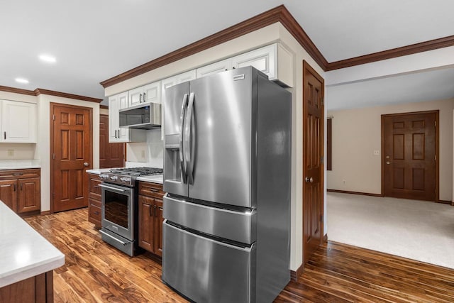 535 Maple Bluff Rd, Stevens Point, WI 54482 - kitchen with appliances with stainless steel finishes, crown molding, wood finished floors, light countertops, and white cabinets