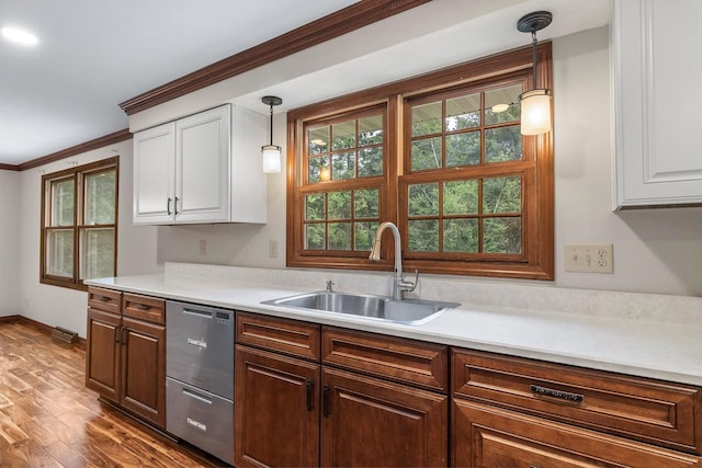 535 Maple Bluff Rd, Stevens Point, WI 54482 - kitchen featuring stainless steel dishwasher, white cabinetry, plenty of natural light, hanging light fixtures, and ornamental molding