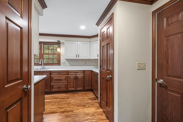 535 Maple Bluff Rd, Stevens Point, WI 54482 - kitchen with crown molding, light wood-type flooring, light countertops, white cabinets, and recessed lighting