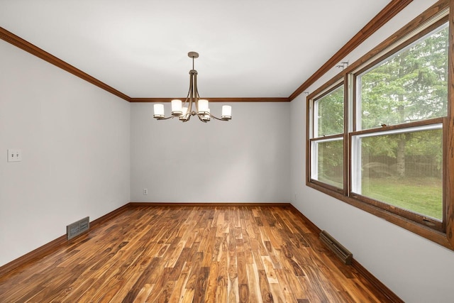 535 Maple Bluff Rd, Stevens Point, WI 54482 - unfurnished room with healthy amount of natural light, a chandelier, ornamental molding, and wood finished floors