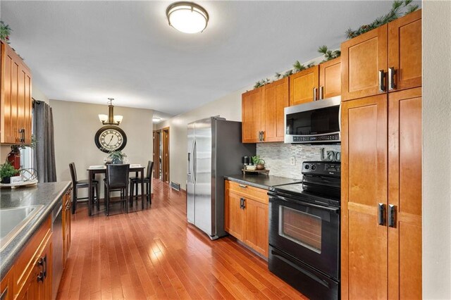 1516 Mitscher Ave, Eau Claire, WI 54701 - kitchen with appliances with stainless steel finishes, brown cabinets, dark countertops, and hardwood / wood-style flooring