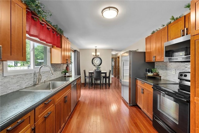 1516 Mitscher Ave, Eau Claire, WI 54701 - kitchen with stainless steel appliances, dark countertops, decorative backsplash, and light wood-type flooring