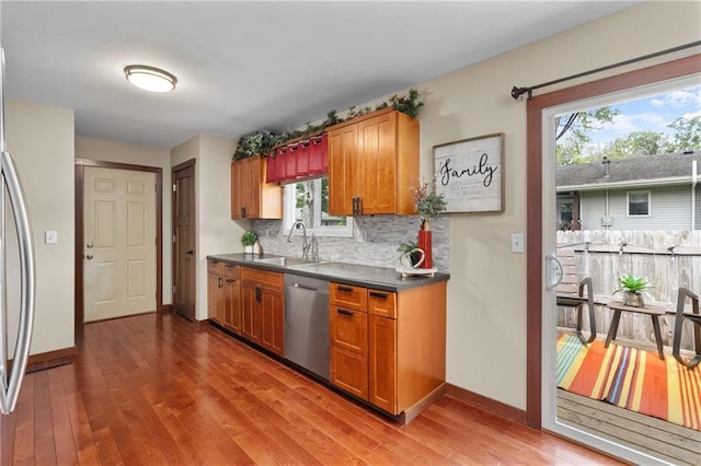 1516 Mitscher Ave, Eau Claire, WI 54701 - kitchen featuring appliances with stainless steel finishes, brown cabinets, tasteful backsplash, and wood finished floors