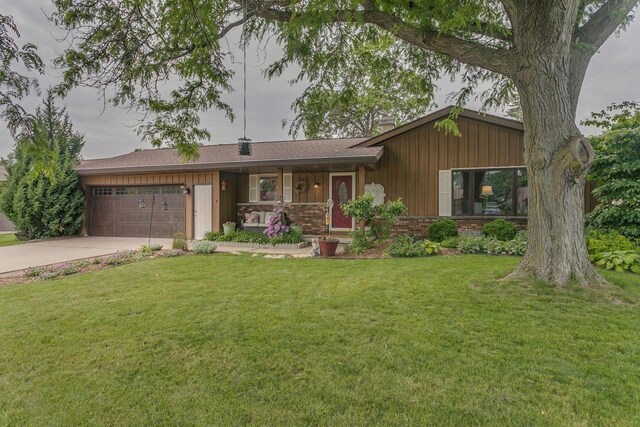 1801 N Mc Intosh Dr, Appleton, WI 54914 - view of front of house featuring a porch, concrete driveway, a chimney, an attached garage, and a front lawn