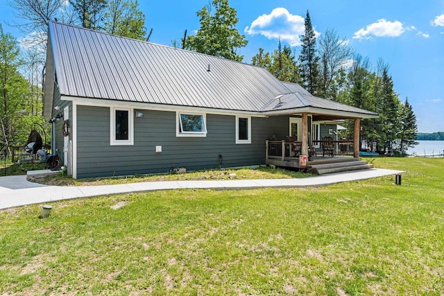 9071 Doemel Ln, Pickerel, WI 54465 - rear view of house featuring a lawn, a metal roof, a water view, and covered porch