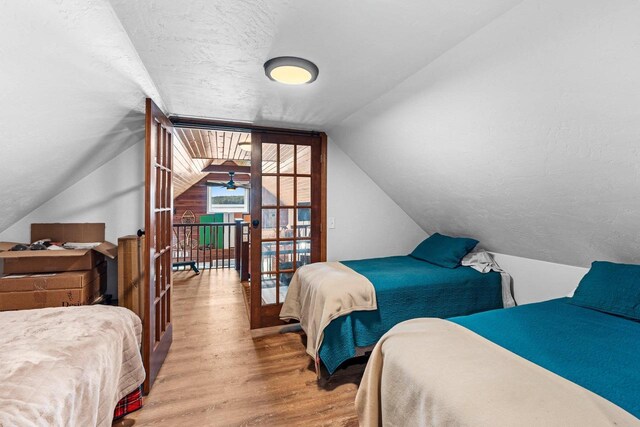 9071 Doemel Ln, Pickerel, WI 54465 - bedroom featuring wood finished floors, lofted ceiling, and a textured ceiling