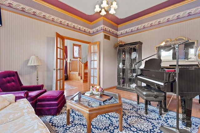 1020 Victorian Ln, Plover, WI 54467 - living room with wallpapered walls, a chandelier, french doors, stairs, and wood finished floors