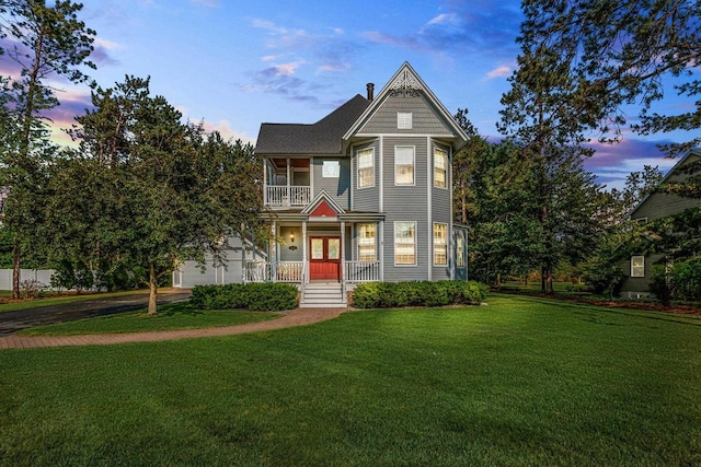 1020 Victorian Ln, Plover, WI 54467 - victorian house featuring covered porch, a yard, a garage, and a balcony