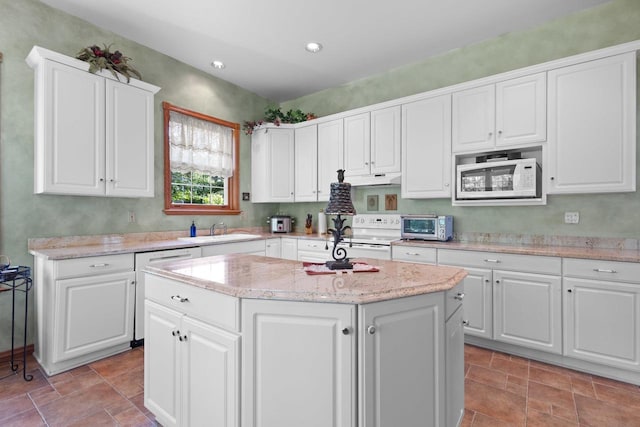 1020 Victorian Ln, Plover, WI 54467 - kitchen featuring white appliances, a kitchen island, white cabinetry, recessed lighting, and light stone counters