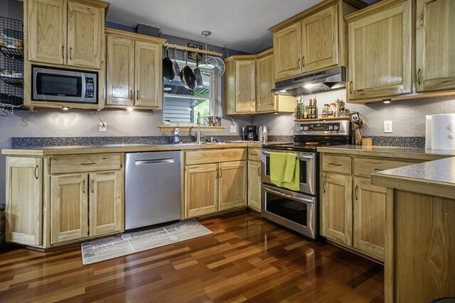 3933 Lovers Ln Unit 3935, 3937, 3939, 39, Slinger, WI 53086 - kitchen featuring stainless steel appliances, under cabinet range hood, dark wood finished floors, a textured wall, and hanging light fixtures