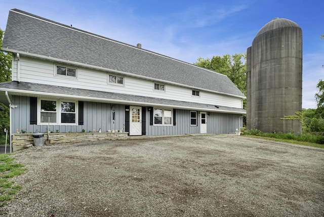 3933 Lovers Ln Unit 3935, 3937, 3939, 39, Slinger, WI 53086 - view of front of house with board and batten siding, a shingled roof, and asphalt driveway