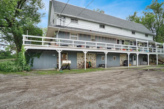 3933 Lovers Ln Unit 3935, 3937, 3939, 39, Slinger, WI 53086 - rear view of property with a wooden deck, roof with shingles, and a chimney