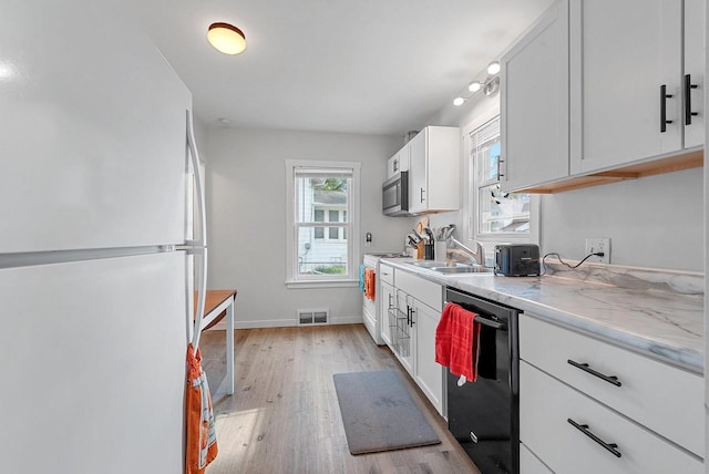 210 S Summit St, Appleton, WI 54914 - kitchen with freestanding refrigerator, dishwasher, stainless steel microwave, light wood finished floors, and white cabinets