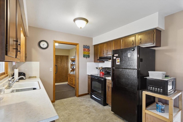 197 Juniper Ave, Brodhead, WI 53520 - kitchen featuring black appliances, under cabinet range hood, backsplash, and light countertops