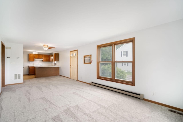 2560 Pebble Valley Rd, Waukesha, WI 53188 - unfurnished living room with baseboard heating, light colored carpet, ceiling fan, and a wall mounted air conditioner