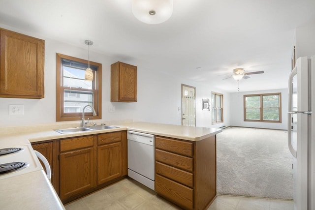 2560 Pebble Valley Rd, Waukesha, WI 53188 - kitchen with white appliances, a peninsula, brown cabinets, open floor plan, and light countertops