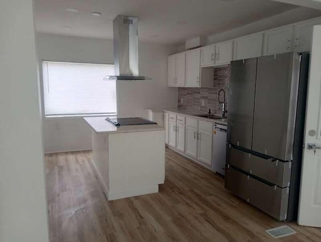 6460 N 91st St, Milwaukee, WI 53224 - kitchen with freestanding refrigerator, island range hood, black electric cooktop, white cabinetry, and tasteful backsplash