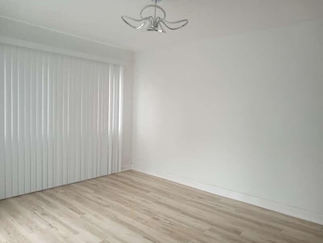 6460 N 91st St, Milwaukee, WI 53224 - unfurnished room with wood finished floors and a chandelier