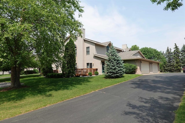 284 White Oak Ave Unit 8, Plover, WI 54467 - view of property hidden behind natural elements featuring a chimney, a front yard, an attached garage, and driveway
