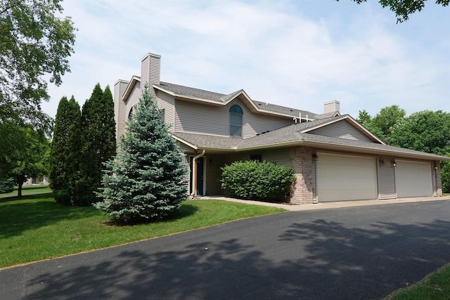 284 White Oak Ave Unit 8, Plover, WI 54467 - view of front of property featuring a chimney, an attached garage, a front yard, and asphalt driveway