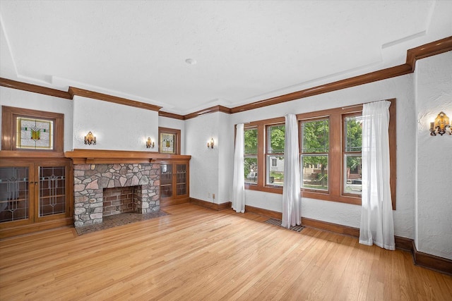 2767 S Herman St, Milwaukee, WI 53207 - unfurnished living room featuring a textured wall, light wood-type flooring, ornamental molding, and a fireplace