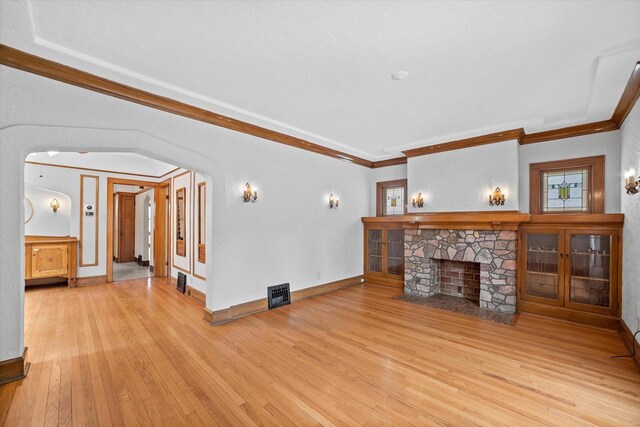 2767 S Herman St, Milwaukee, WI 53207 - unfurnished living room featuring hardwood / wood-style flooring, a fireplace, arched walkways, and crown molding