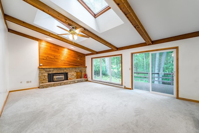 1705 Stark St, Wausau, WI 54403 - unfurnished living room featuring a baseboard heating unit, a skylight, carpet flooring, a stone fireplace, and ceiling fan