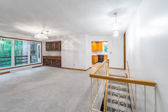 1705 Stark St, Wausau, WI 54403 - unfurnished living room with a chandelier, light carpet, a textured ceiling, and baseboard heating