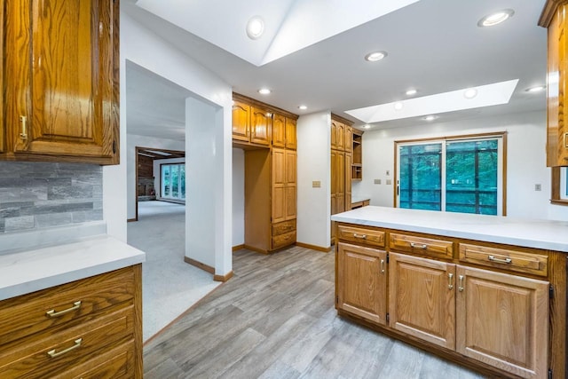 1705 Stark St, Wausau, WI 54403 - kitchen with recessed lighting, brown cabinets, light countertops, light wood finished floors, and a peninsula