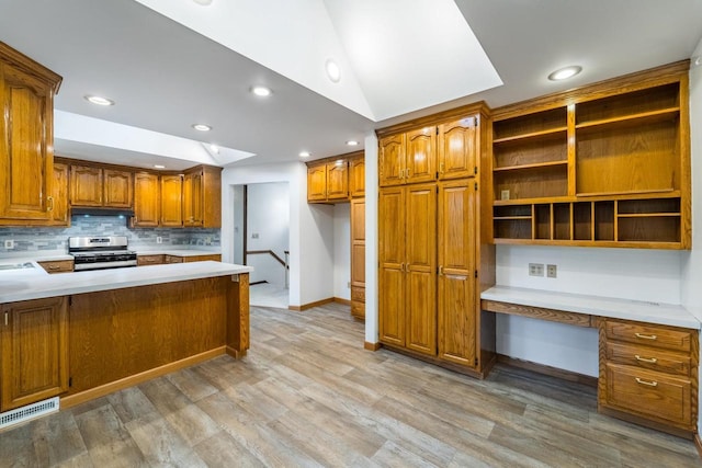 1705 Stark St, Wausau, WI 54403 - kitchen featuring stainless steel range with gas stovetop, built in study area, brown cabinetry, light countertops, and light wood finished floors