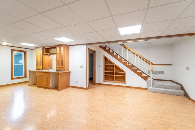 1705 Stark St, Wausau, WI 54403 - unfurnished living room with light wood-type flooring, stairway, a paneled ceiling, and built in shelves