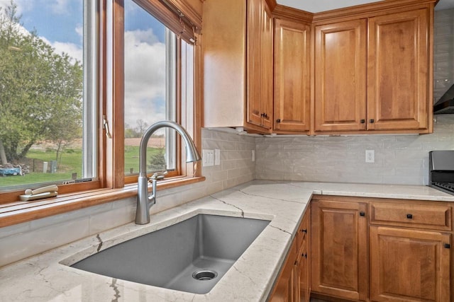1106 Lake Largo Dr, Green Bay, WI 54311 - kitchen featuring brown cabinetry, backsplash, light stone countertops, and stove