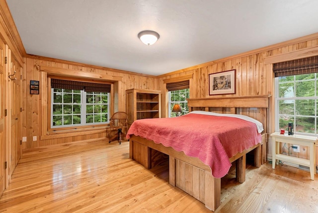 N5730 Parkway Rd, Pound, WI 54161 - bedroom featuring wood walls, multiple windows, light wood-style flooring, and ornamental molding