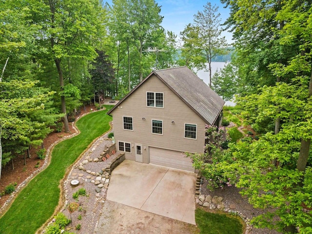 N5730 Parkway Rd, Pound, WI 54161 - view of property exterior featuring a garage, driveway, a shingled roof, and view of wooded area
