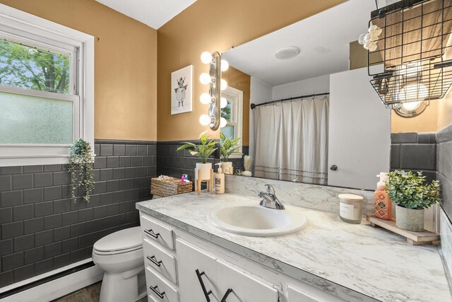 551 Market Ave, Port Edwards, WI 54469 - bathroom featuring a baseboard radiator, tile walls, vanity, and a wainscoted wall