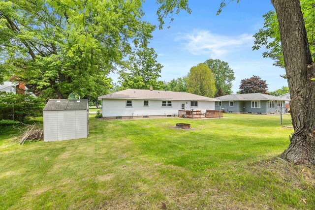 551 Market Ave, Port Edwards, WI 54469 - back of property with a shed, an outdoor fire pit, a yard, and a wooden deck