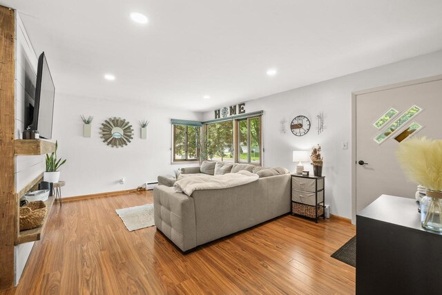 551 Market Ave, Port Edwards, WI 54469 - living room featuring wood finished floors, recessed lighting, a baseboard radiator, and a fireplace