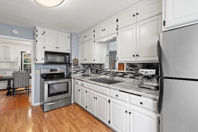 6738 W Monona Pl, West Allis, WI 53219 - kitchen featuring stainless steel appliances, white cabinets, backsplash, and light wood-style floors