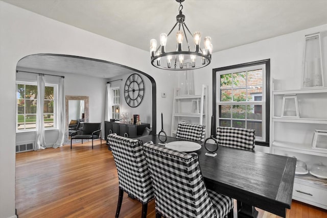 6738 W Monona Pl, West Allis, WI 53219 - dining area featuring arched walkways, plenty of natural light, and wood finished floors