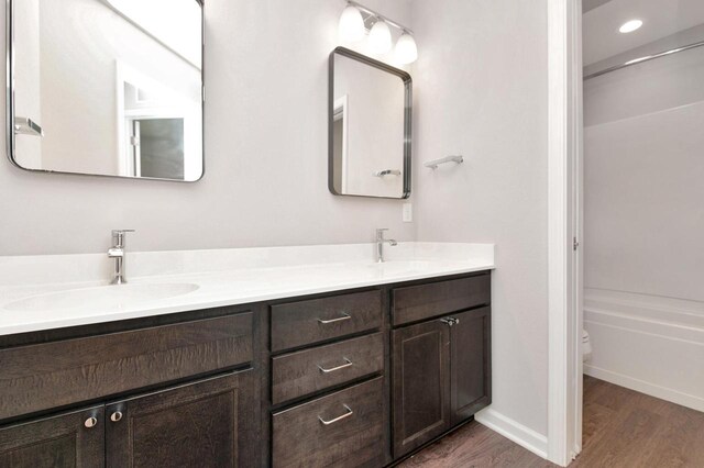 W356N6752 E Stonewood Dr, Oconomowoc, WI 53066 - bathroom featuring double vanity, wood finished floors, and recessed lighting
