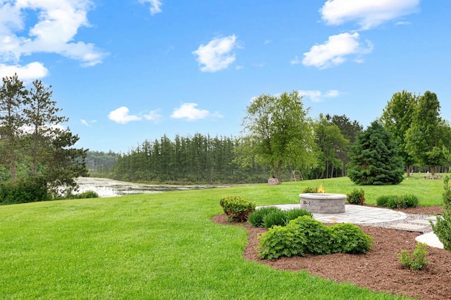 W356N6752 E Stonewood Dr, Oconomowoc, WI 53066 - view of green lawn featuring a fire pit, a water view, and a patio area