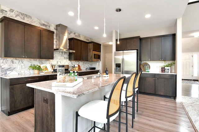 W356N6752 E Stonewood Dr, Oconomowoc, WI 53066 - kitchen with wall chimney range hood, stainless steel appliances, dark brown cabinets, decorative backsplash, and recessed lighting