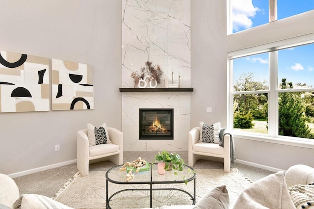 W356N6752 E Stonewood Dr, Oconomowoc, WI 53066 - carpeted living room with a fireplace, healthy amount of natural light, and a high ceiling