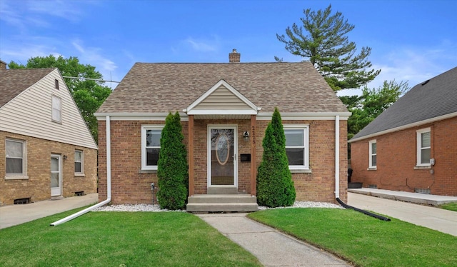 2225 Shoop St, Racine, WI 53404 - view of front of house with brick siding, a chimney, a front yard, and a shingled roof