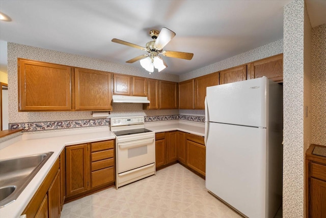 1819 Sumac Ct Unit A, Grafton, WI 53024 - kitchen with white appliances, under cabinet range hood, brown cabinetry, and a ceiling fan